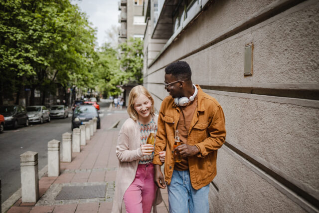young couple arm in arm city streets