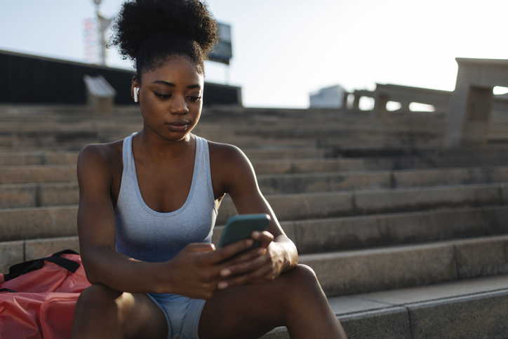 Woman texting at the track.