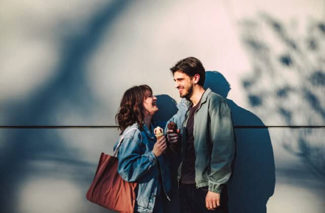young man woman eating ice cream outdoors