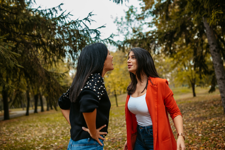 two female friends arguing in park