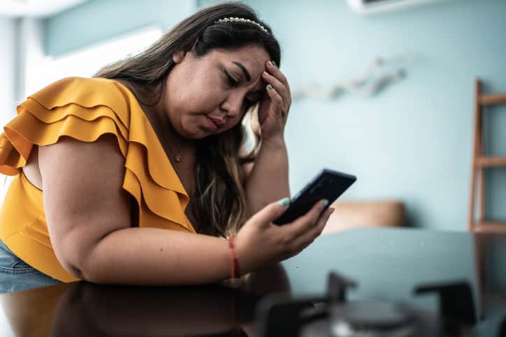 sad woman texting on phone