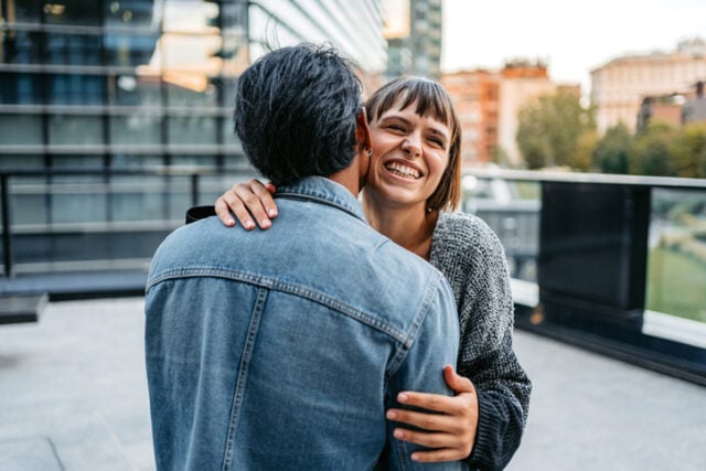 couple embracing on sunny rooftop