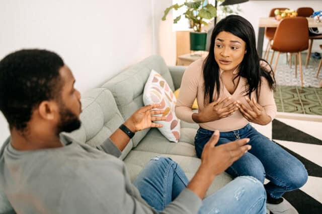 couple arguing on living room couch