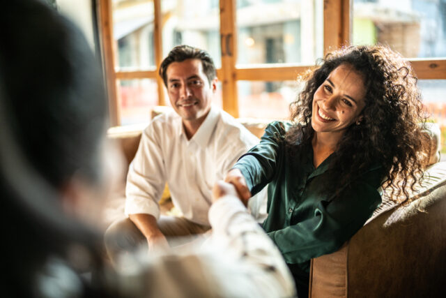 smiling woman shaking someone's hand