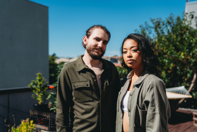 serious millennial couple on sunny rooftop