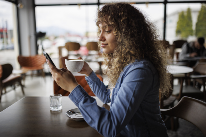 Woman texting at coffee shop.