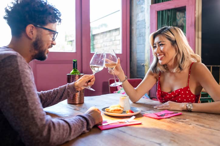 couple cheersing wine glasses date
