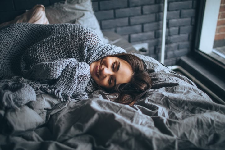 smiling woman sleeping in bed