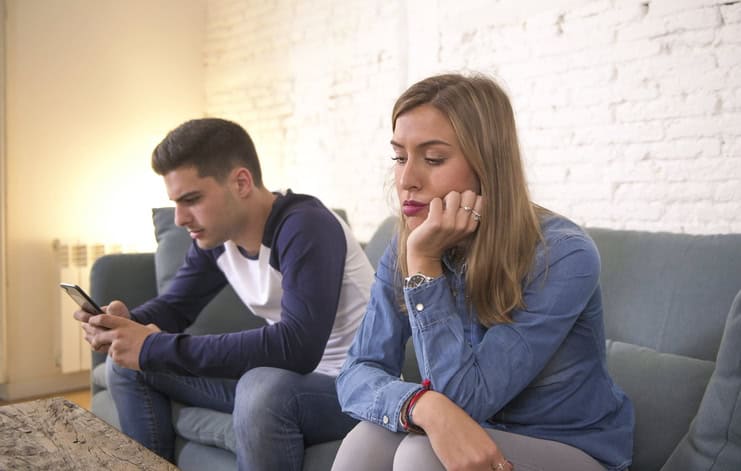 boyfriend ignoring girlfriend on couch