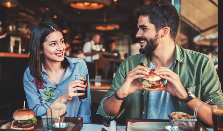 Happy loving couple enjoying breakfast in a cafe. Love, dating, food, lifestyle concept