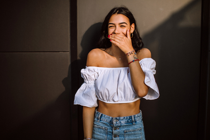 smiling shy woman on city street