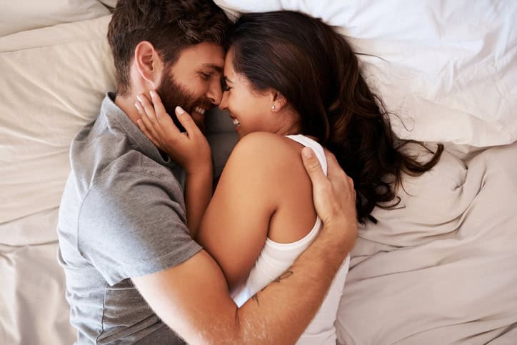 Shot of an affectionate young couple embracing in bed at home