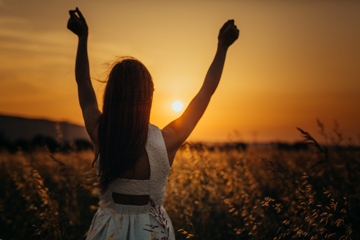 Woman in the field having fun sunset