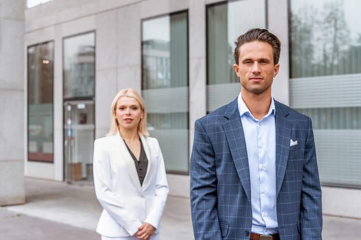 Portrait of a young adult businessman and businesswoman outdoors.