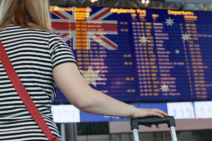 Woman looking at departures sign in airport.