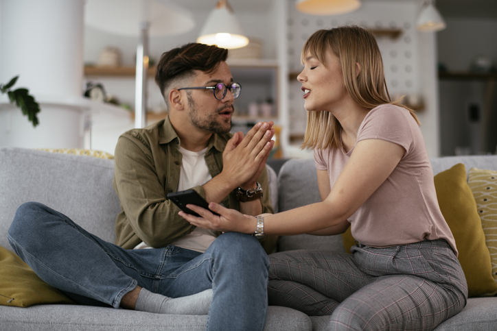 Boyfriend and girlfriend are arguing on the couch.