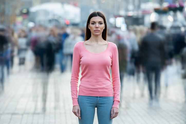 Woman standing on the sidewalk in the city.