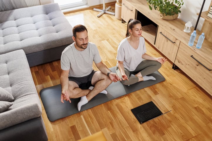 High angle view of couple doing online meditation session together at home