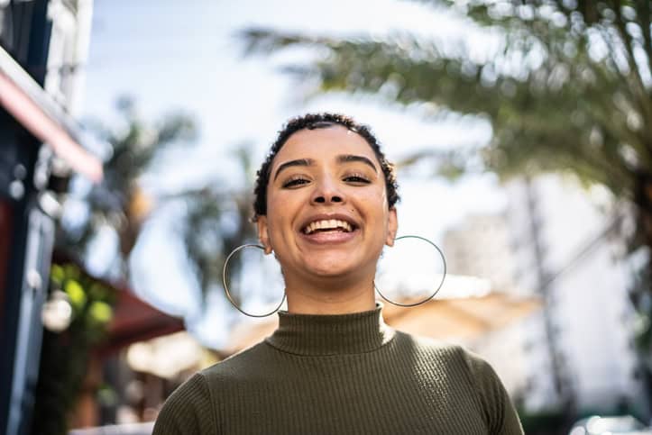 confident millennial woman smiling outside