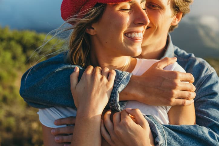 couple cuddling on mountain summer