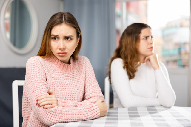 two friends in an argument looking away