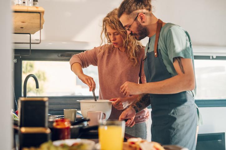 Young couple making breakfast together in the kitchen at home.