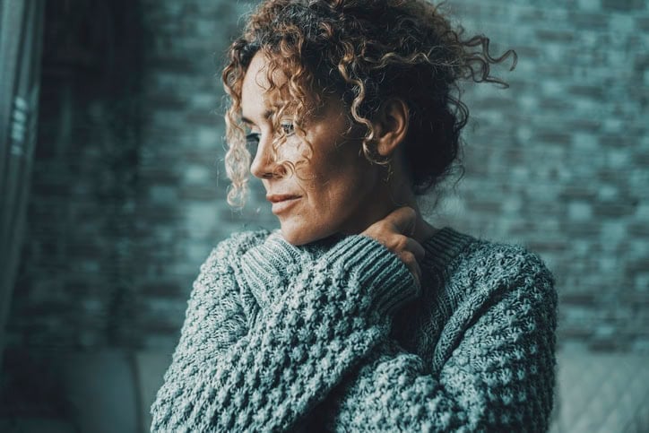Woman with her hands on her neck.
