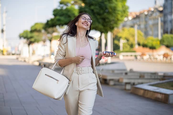 Woman listening to music and dancing on the street
