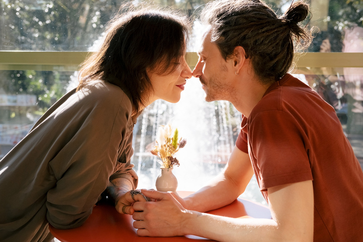 Couple sharing romantic kiss in a cafe.
