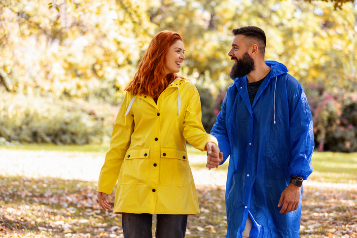 Young couple in love is enjoying in park after rain.