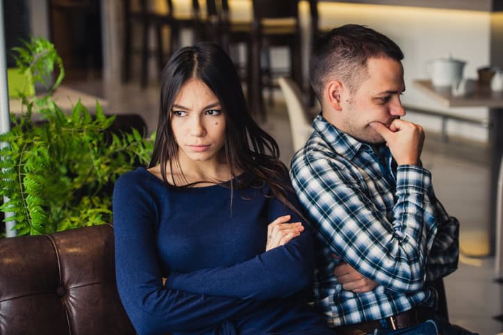 Couple at cafe during lunch, serious.