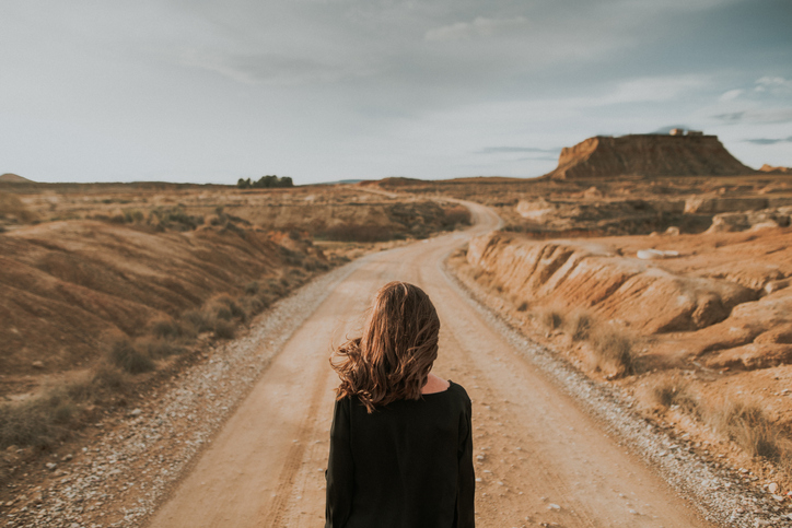 Rear view of woman at desert road.