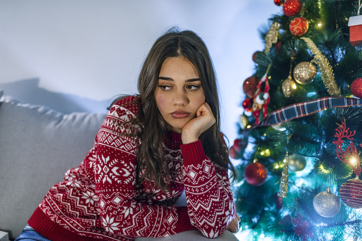 Tired woman with chin in hand at Christmas.