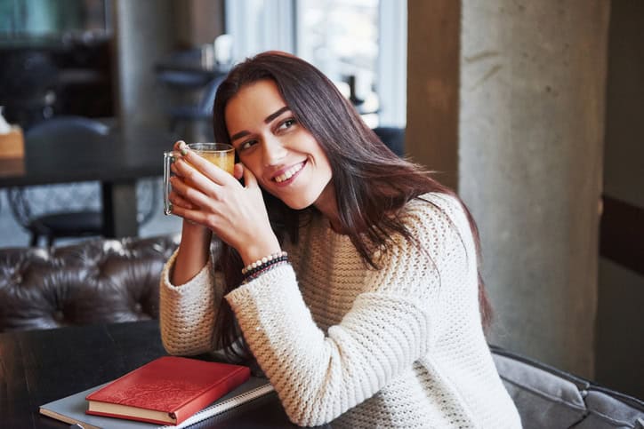 Woman sitting in a restaurant with a book.