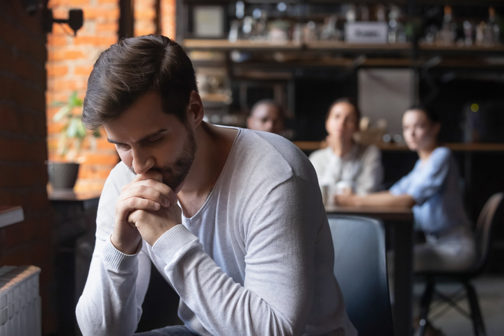 Sad man sitting alone in a cafe.