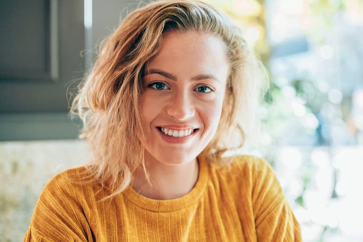 Portrait of beautiful smiling woman sitting on a table in urban cafe.