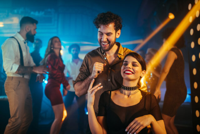 An affectionate young couple dancing at a party in a nightclub