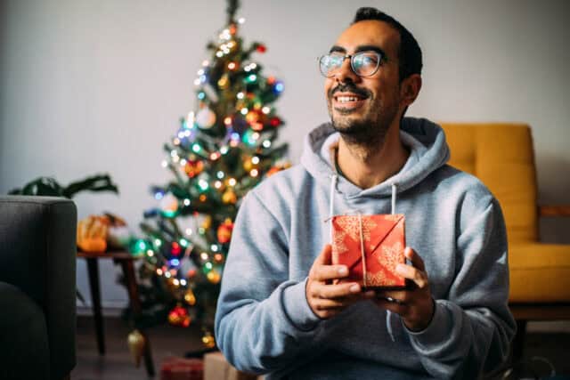 guy with christmas tree in background