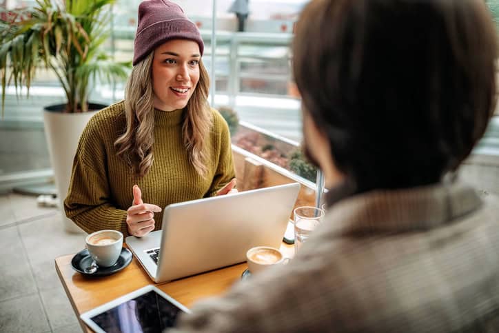 Young couple doing freelance work in cafe
