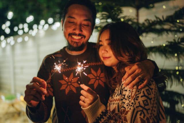 couple sharing sparklers at holiday