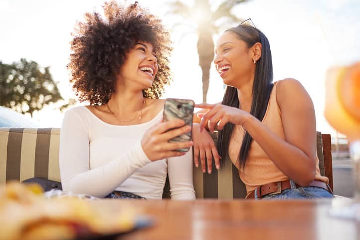 Two friends laughing at a restaurant.
