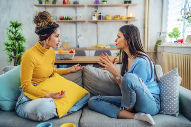 female friends arguing on couch