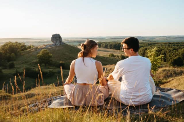 couple sitting and overlooking mountain