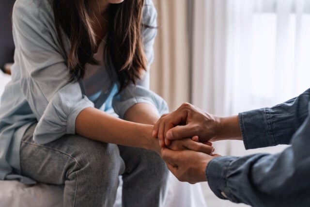 man and woman holding hands in supportive motion
