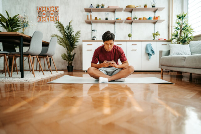 asian man doing yoga on floor