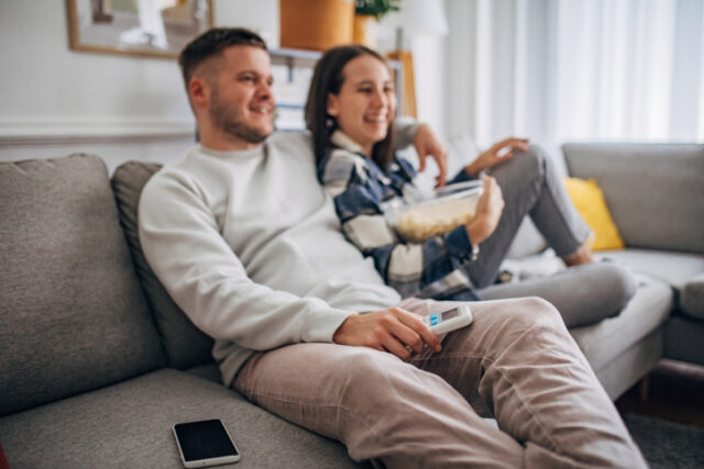 Young couple relaxing at home watching TV.