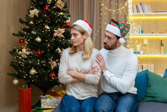 man touching upset girlfriend on christmas