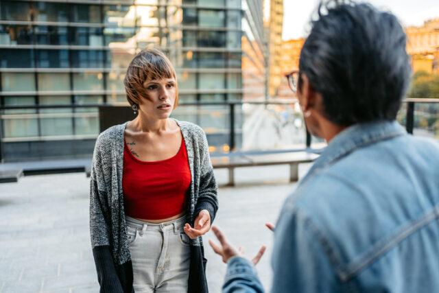 Young multiracial couple having a conflict on the street in Milan, Italy.