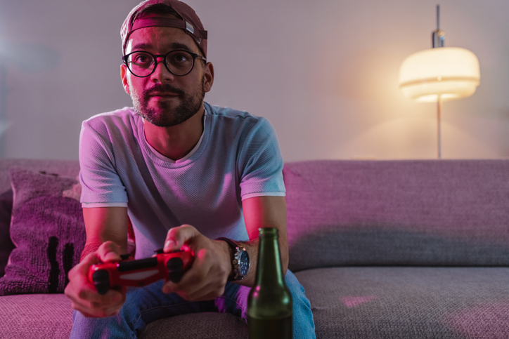 millennial man playing video games on couch