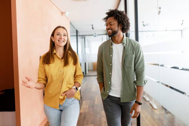 Couple of business people discussing tasks walking in the office hall
